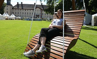Entspannt: Charmaine Haid vom Veranstalter Evergreen hat Platz genommen auf der bequemen Holzliege eines Anbieters vor dem Schloss Corvey. - Simone Flörke