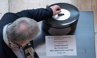 Ein Abgeordneter wirft bei der namentlichen Abstimmung über den Gesetzentwurf der Koalition in eine Wahlurne. - picture alliance/dpa