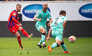 Heidenheims Jan-Niklas Beste (l.) hat SCP-Verteidiger Jannis Heuer (M.) vernatzt und schießt zum 1:0 für Heidenheim ein. Uwe Hünemeier kommt zu spät. - Imago Images