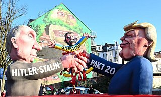 Auf einem der Düsseldorfer Rosenmontagswagen schließen Donald Trump und Wladimir Putin einen «Hitler-Stalin-Pakt 2.0» auf Kosten der Ukraine ab. - Federico Gambarini/dpa