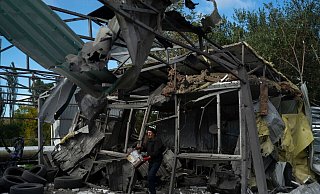 Nach dem russischen Raketenangriff löscht ein Mann in Saporischschja die Überreste eines Feuers in einer zerstörten Autowerkstatt. - Leo Correa/AP/dpa