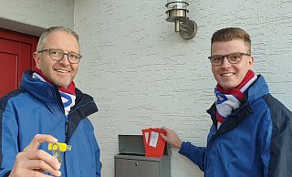 Präsident Matthias Gersch (l.) und sein Stellvertreter Lukas Wöstefeld verteilen USB-Sticks mit dem Karnevalsfilm und Bildern vergangener Tage. - Karnevalsverein Ovenhausen