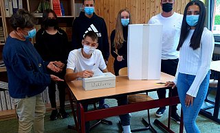 Probelauf an der improvisierten Wahlkabine: Gemeinsam mit ihren Lehrern Anke Hippe-Schuster (l.) und Sebastian Block (2.v.r.) haben die Zehntklässler Juliana Kalderus, Nico Arensmeyer, Leonie Brünger und Inas Hajismo (stehend v.l.) alles über die Kommunalwahl gelernt. Jonas Schröder wirft derweil seinen "Stimmzettel" in die Wahlurne im Schuhkarton. - Martina Chudzicki