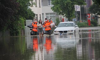 Feuerwehrmänner begleiten eine Frau im Juni 2021 durch das Hochwasser an der Engerstraße. - Florian Weyand (Archivfoto)