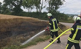 Im Einsatz: Die Feuerwehr löscht ein Kornfeld bei Lüchtringen. - Feuerwehr Höxter