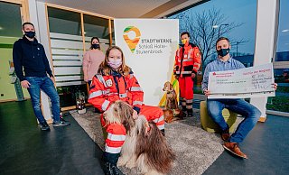 Die Stadtwerke Schloß Holte-Stukenbrock, hier mit Geschäftsführer Marco Fuhrmann (rechts), den Mitarbeitern Pascal Schippling (von links) und Annika Ruhe-Götzke unterstützen die Arbeit der BRH-Rettungshundestaffel Lippe-Ems mit einer Spende von 300 Euro. Diesen Betrag wollen die Staffel-Gruppenführerin Pauline Synowski mit Frieda und die Staffel-Vorsitzende Kirstin Ewerszumrode mit Luna und Emmy für die Anschaffung neuer GPS-Geräte nutzen. - Besim Mazhiqi