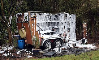 Der zu einem Wohnwagen umgebaute Pferdeanhänger wurde ein Raub der Flammen. Foto: Polizei Minden-Lübbecke - Eike J. Horstmann