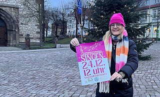 Valeria Geritzen mit dem Plakat fürs Weihnachtssingen am Christbaum auf dem Neustädter Marktplatz. - Privat