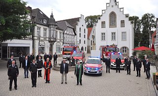 Auf dem Marktplatz hat Bürgermeister Hermann Temme (2. v. r.) drei Fahrzeuge (vorn) an Sven Heinemann, den Leiter der Feuerwehr Brakel (2. v. l.) übergeben. - Helga Krooß