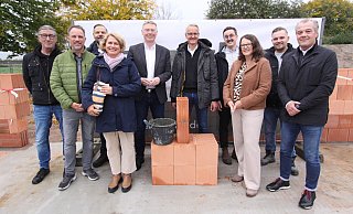 Michael Hampe (Projektentwickler, v. l.), Jörg Luttmann (Leiter Sozialamt Hiddenhausen), Christian Rehberg (Regionalvorstand Johanniter Unfall-Hilfe), Kirsten Küppers (Kreis Herford), Bürgermeister Andreas Hüffmann, Ralf Haske, Yannick Haske (beide Haske-Bau), Christine Hallmann (Kreis Herford), Johannes Kathöfer (Bauleitung) und Paul Sander (Projektentwickler) bei der Grundsteinlegung. - Björn Kenter