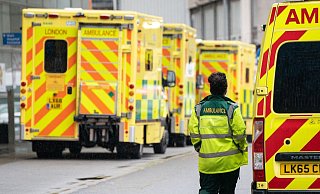 Eine Rettungssanitäterin geht an einer Reihe Krankenwagen vor einem Londoner Krankenhaus vorbei. - Foto: Dominic Lipinski/PA Wire/dpa
