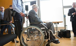 Der im Rollstuhl sitzende Angeklagte Reinhold Hanning wird in den Verhandlungssaal in Detmold gefahren. - Friso Gentsch