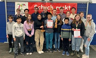 Das gemeinsame Gruppenfoto von den NRW-Titelkämpfen in Hamm zeigt die siegreichen Teams vom Pelizaeus-Gymnasium und vom Gymnasium Schloß Neuhaus sowie Schachtrainer Zoltán Nagy. - Privat