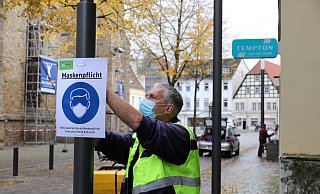 Jürgen Klinksiek von der SWK hängt erste Maskenpflicht-Schilder am Rand der Fußgängerzone auf. - Frank-Michael Kiel-Steinkamp