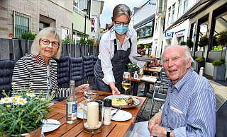 Neues Lebensgefühl auf der Ritterstraße: Cecilie und Rudolf Schunicht genießen das Essen in der neuen Außengastronomie von Klötzer’s Restaurant, Bedienung Kerstin Niemann ist froh, wieder bedienen zu dürfen. Der Altstadt-Test macht’s möglich. - Barbara Franke