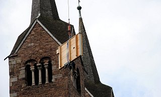 Spektakulärer Einsatz in Corvey: Die Elemente der Balganlage der restaurierten Orgel fliegen an den Türmen des Westwerks vorbei in den Dachraum der Kirche. - Kirchengemeinde