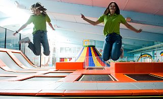 Jessica Leinerschmidt (16, l.) und Joelle Plisko (19) gehören zum Team, dass die großen und kleinen Besucher im Springolino betreut und freuen sich mit ihnen über das Ende der Maskenpflicht. - Ralf Bittner