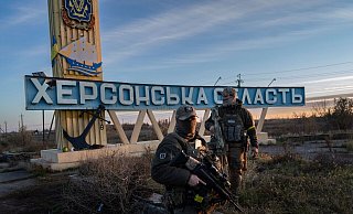 Zwei ukrainische Soldaten stehen neben einem Schild mit der Aufschrift «Region Cherson». Die Stadt Cherson wurde Mitte November von der Ukraine zurückerobert. - Bernat Armangue/AP/dpa