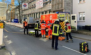 Die Mitglieder des Rettungsdienstes und der Berufsfeuerwehr haben den Verletzten aus der Baustelle getragen und heben ihn nun um, damit er im Rettungswagen transportiert werden kann. - Foto: Jens Reichenbach