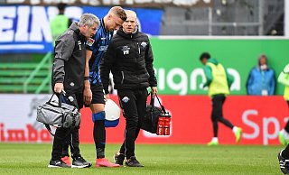 SCP-Mannschaftsarzt Matthias Porsch (l.) und Physiotherapeut Robert Wezorke geleiten den am Knie verletzten Felix Platte vom Platz. - picture alliance