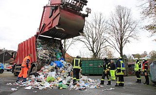 Nachdem die ersten Flammen gelöscht waren, ließ die Feuerwehr den gesamten Abfall auf dem Dorfplatz in Siddessen abkippen, um sicherzustellen, dass sich nicht noch irgendwo versteckte Glutnester befinden. - David Schellenberg