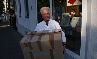 Siegfried Plehn, Inhaber der Sparrenberg Apotheke, hilft beim Verkauf der Shirts und Hoodies für die kleine Leni. - Gregor Winkler