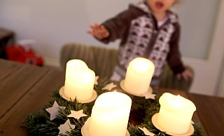 Kinder freuen sich, wenn die Kerzen auf dem Adventskranz leuchten. Die können mitunter aber gefährlich für die Kleinen werden. - Mascha Brichta/dpa (Symbolbild)
