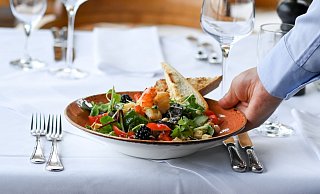 Ein Salat-Teller wird in einem Restaurant serviert. Essengehen wird im kommenden Jahr noch einmal deutlich teurer. - Jens Kalaene/dpa