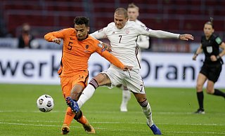 Der Lette Antonijs Cernomiordijs (r) und der Niederländer Owen Wijndal kämpfen um den Ball. - Foto: Peter Dejong/AP/dpa
