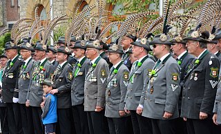 In Reih und Glied: Die Oerlinghauser Schützen mit ihren auffälligen Fasanenfedern auf den Hüten stehen auf dem Rathausplatz. Marius Schmidt hat die Hand auf die Schulter seines Sohnes gelegt. - Karin Prignitz