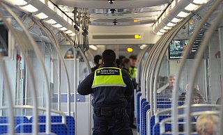 Ein Mitarbeiter eines Sicherheitsdienstes kontrolliert Fahrgäste in einer S-Bahn. - Neue Westfälische
