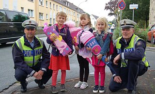 Passen auf: Polizeioberkommissar Rainer Hoberg (l.) und Polizeioberkommissar Reinhard Schnitz mit drei Schulanfängern mit ihren Schultüten. - Polizei Paderborn