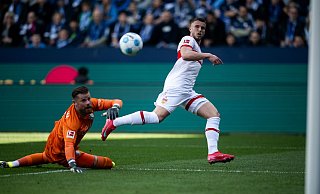 Ermedin Demirovic lupft den Ball über Timo Horn zum 2:0 ins Netz. - Fabian Strauch/dpa