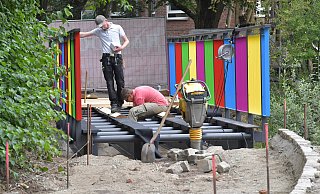 Mitarbeiter eines Unternehmens aus Stralsund sind damit beschäftigt, die neue Dalkebrücke samt farbenfrohem Geländer im Webereipark zu montieren. - Jens Dünhölter