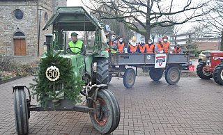 Mit Jubiläumskranz 50 Jahre: Der Trecker vom Hof Lütkemeier dreht auf dem Parkplatz vor der Kirche in KIrchlengern bei der Aktion "Nadelnder Tannenbaum" - Thorsten Mailänder