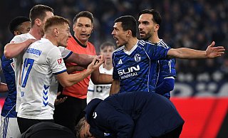 Laurin Curda (l.) diskutiert mit den Schalkern Ron Schallenberg und Kenan Karaman (hinten r.). Curda und Karaman kassieren am Ende die Gelbe Karte. - picture alliance / DeFodi Images