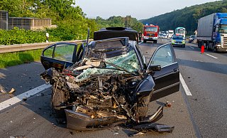 Zusammengedrückt bis zur Frontscheibe. Der dunkle BMW ist nur noch ein Wrack. - Feuerwehr Porta / Michael Horst