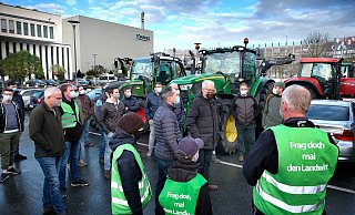 Rund 40 Landwirte äußeren ihren Unmut vor dem Fleischwerk Tönnies über die gesenkten Schweinepreise. Dass die Bauern nun noch dringlicher das Gespräch mit Verarbeiten und Handel suchen, macht Alfred Micheel mit seiner Weste deutlich. Er ist mit seinen Kindern Linus und Inga aus Ennigerloh zu der Kundgebung gekommen. - Andreas Frücht