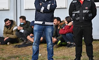Wachpersonal steht vor der Zentralen Erstaufnahmeeinrichtung für Asylbewerber (ZABH) des Landes Brandenburg in Eisenhüttenstadt. - Patrick Pleul/dpa-Zentralbild/dpa