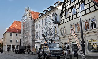 Mitarbeiter des Schaustellerbetriebes Küchenmeister haben damit begonnen, Lichterketten in die Bäume am Neuen Markt zu hängen. - Frank-Michael Kiel-Steinkamp