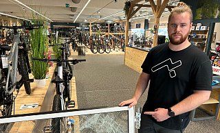Werkstattleiter Dominik Riegel (24) zeigt die zersplitterte Eingangstür. des Cube-Fahrradladen in Gütersloh. - Christian Bröder