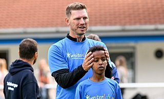 Fabian Klos erläutert den C-Jugendlichen des TuS Hoberge-Uerentrup, hier Mohammed Adem Mohammud, worauf sie beim Kopfball achten müssen. - Christian Weische
