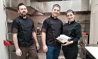 In der kleinen, blitzsauberen Küche präsentieren Inhaber Oleh und Anja Kryvokhyzhenko (Mitte und re) zusammen mit Mitarbeiter Kostja Nechvoloda (li) stolz ihre liebevoll gestalteten Köstlichkeiten. - Gabriele Freimuth