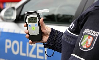 Symbolbild: Ein Beamter zeigt ein Messgerät für Alkohol. - Jochen Tack