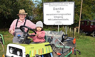 Erstmals beim Kartoffel- und Dreschfest ist Theodor Steiling aus Beelen dabei. Der gelernte Landmaschinenmechaniker hat unter anderem seinen aus Schrottteilen selbst gebauten Mini-Mähdrescher dabei. Auf dem Fahrersitz hat Lenya (20 Monate) Platz genommen. - Karin Prignitz