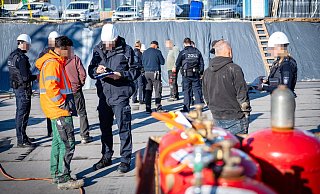 Zollbeamte befragen die Arbeiter auf der Baustelle der Martin-Niemöller-Gesamtschule. - Barbara Franke