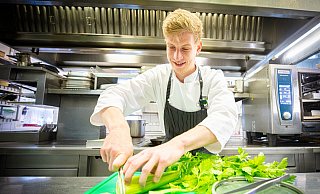 Spitzen-Azubi Lukas Kittel mit seinen beiden Lieblingsinstrumenten: einem scharfen Messer, das wie von selbst durch den Stangensellerie gleitet, und eine Kochpinzette für die Feinarbeit. - Mike-Dennis Müller / www.mdm.photo