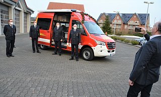 Bürgermeister Hubert Erichlandwehr hält die Einweihung des Einsatzleitwagens mit dem Smartphone fest. Neben dem Wagen stehen der stellvertretende Wehrführer Bruno Wulf, Ulrich Potthoff (verdeckt), Löschzugführer Daniel Kammertöns, Wehrführer Claus Oberteicher und Monsignore Wolfgang Bender. - Karin Prignitz