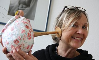 Hebamme Erika Bänsch hört mit dem klassischen Horchrohr der Hebammen den Bauch der schwangeren Figur ab. - Anne Neul