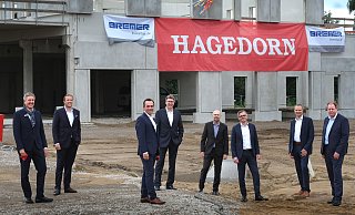 Bürgermeister Henning Schulz (v.l.), Rick Mädel (Hagedorn Revital), Thomas Hagedorn, Gert-Manfred Hornig (Post), Heiko Riedel (DPDHL Real Estate), Bernd Jungholt (Bremer), Andreas Goltz (DPDHL) und Torsten Schuff (Vorstand Bremer AG) freuen sich bei aller Distanzwahrung über den raschen Baufortschritt. - Andreas Frücht